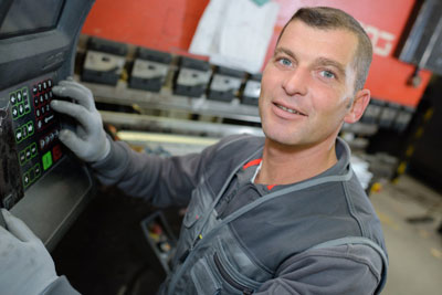 一张专门的工厂工人在自动化机械接口面板上的照片。