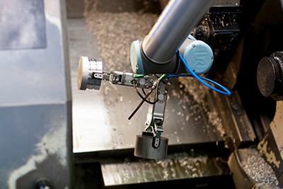 双夹钳使协作机器人臂一次处理更多的部件，增加该数控机床趋势应用中的生产率。（由机器人A / s提供）